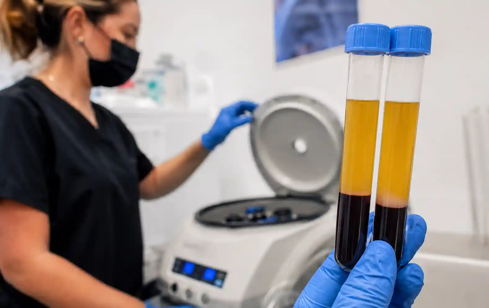 Medical professional preparing platelet-rich plasma (PRP) using centrifuge equipment in a regenerative medicine clinic laboratory